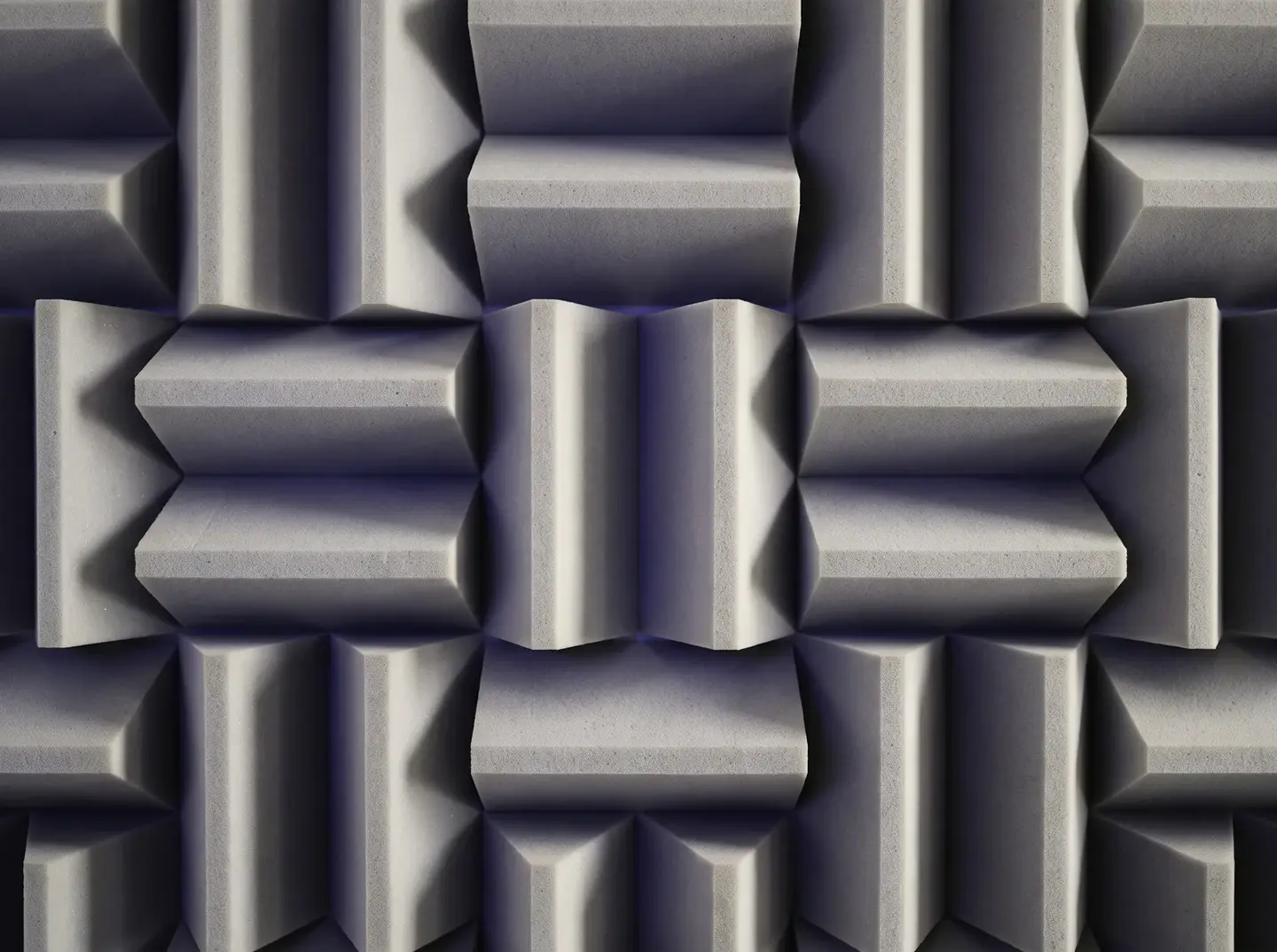 Pale grey acoustic foam wedges in a repeating pattern, lit by soft window light